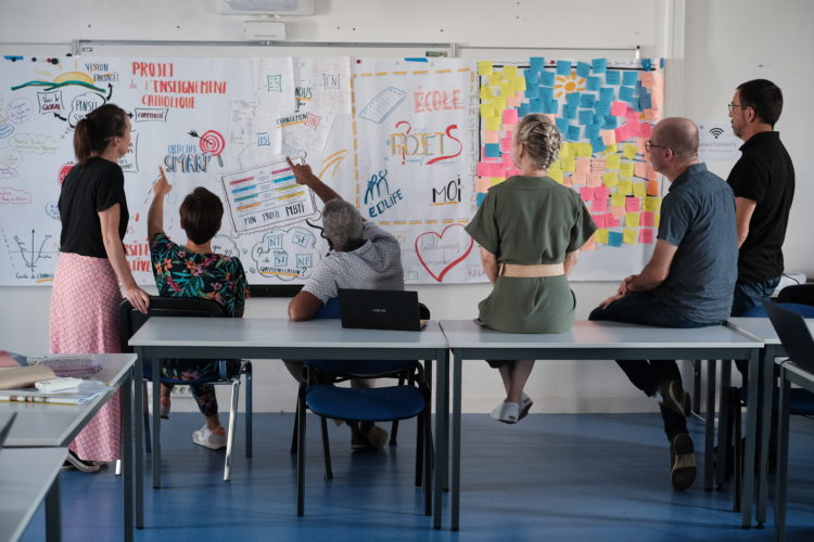 Photo de l'équipe des formateurs et conseillers des formations collectives d'équipes tournés vers un tableau